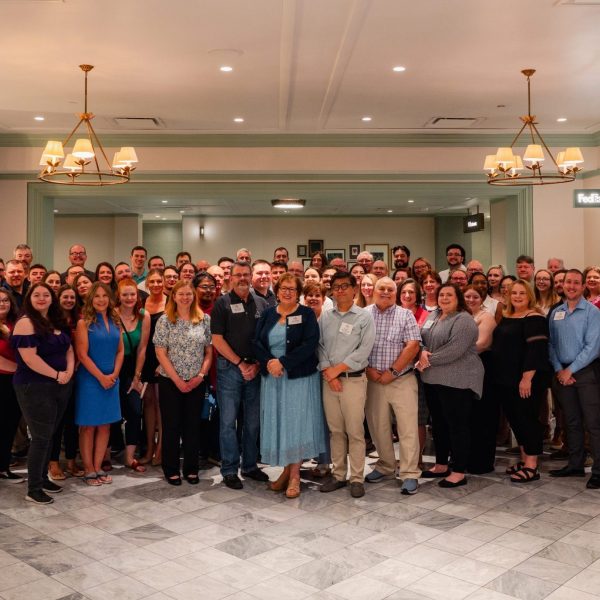 Apogee employees in large group at formal luncheon