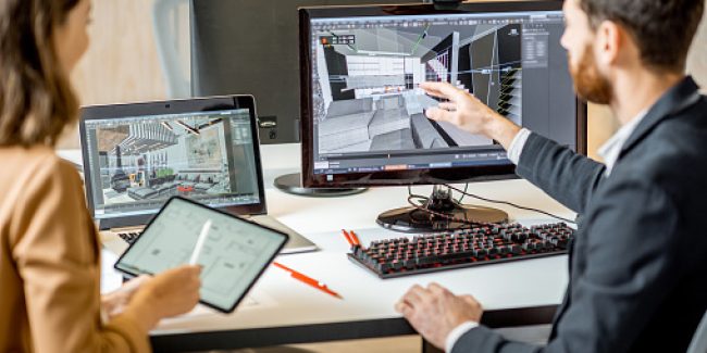 Two office workers looking at rendering of room