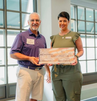 Two people holding a large check