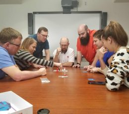 Apogee employees playing games around a table