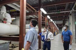 Apogee employees looking at pipes