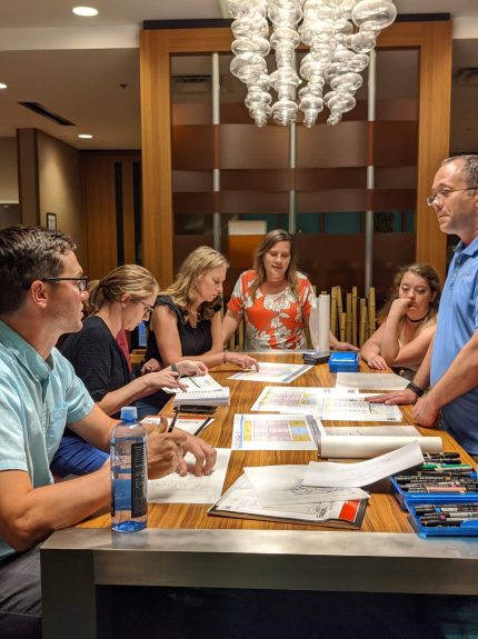 Apogee employees looking at papers around a table