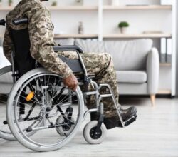 Black veteran in wheelchair rolling through house