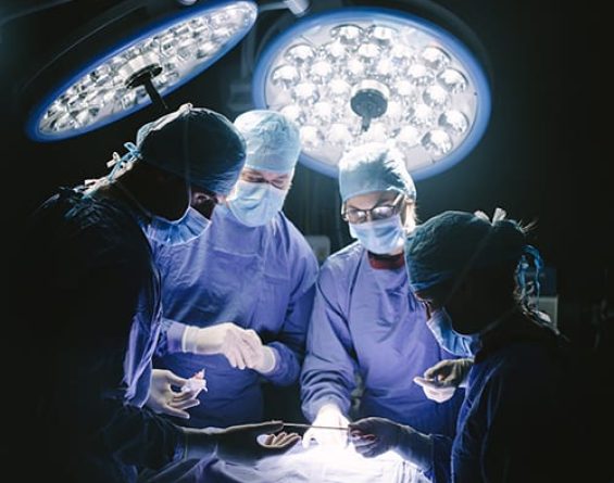 Surgeons in operating room around patient