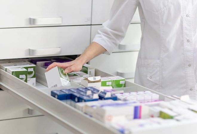 Pharmacist grabbing medication from drawer